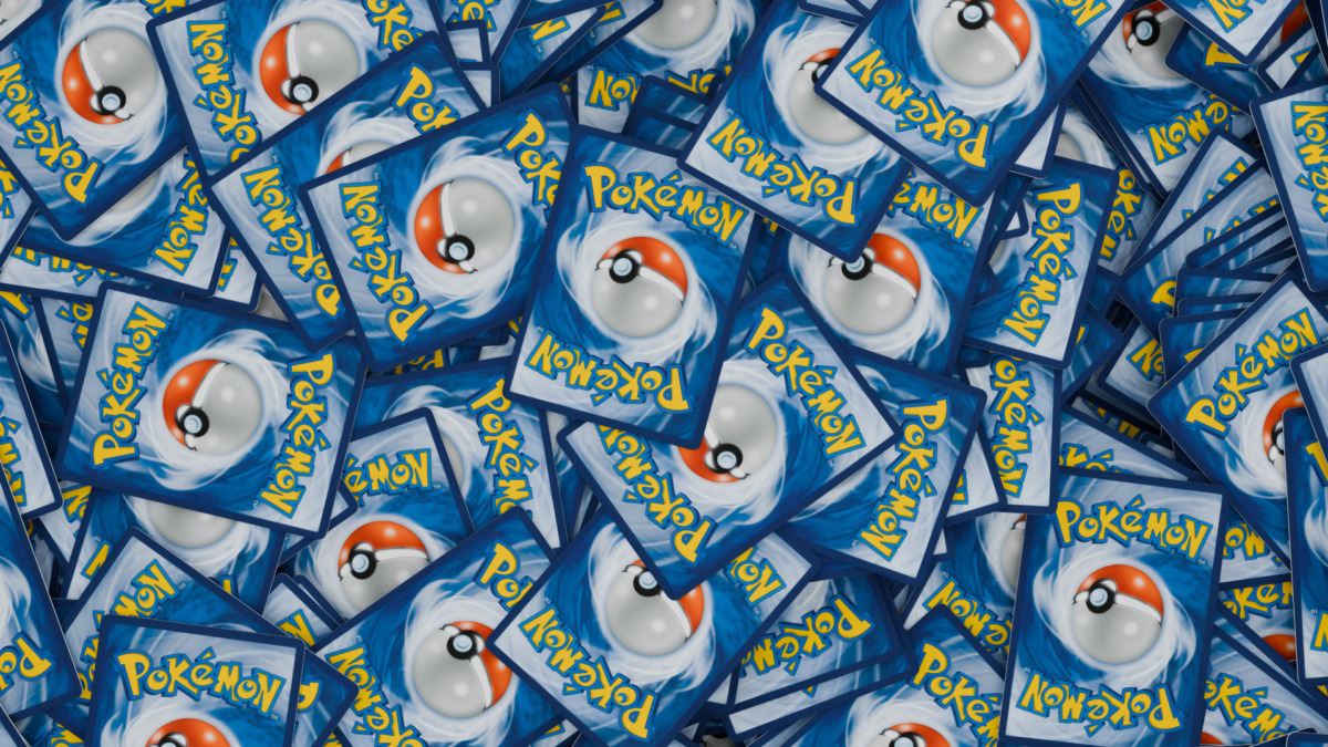 Collector holding smartphone with NFT trading card and slabbed physical Pokémon card, illustrating digital-to-physical redemption process